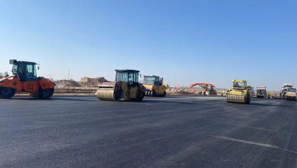 近日，在球王会兰州新区城市矿产与表面处理产业园区（二期）周边基础设施项目—园区西路南延段（纬五十路至纬二十八路）项目现场，随着一辆辆运料车平稳驶入，摊铺机将滚烫的沥青混合料均匀铺开，标志着项